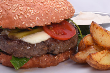 Burger, hamburger with potatoes for homemade and fresh vegetables close-up on a light background.