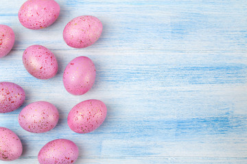 Easter. Pink easter eggs on a blue wooden table. Happy easter. holidays. top view. frame