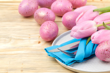 Easter. Easter table setting. Pink Easter eggs and flowers tulips on a natural wooden table. Happy easter. holidays.
