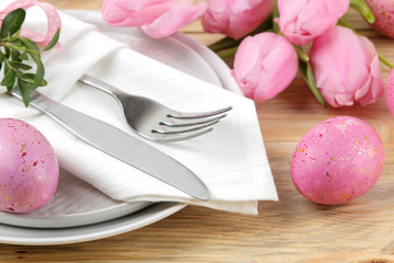 Easter. Easter table setting. Pink Easter eggs and flowers tulips on a natural wooden table. Happy easter. holidays.