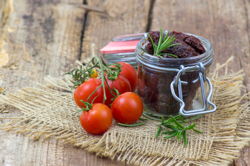 fresh and dried tomatoes on wooden background