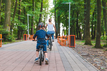 woman teach little boy bicycling