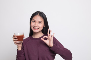 Young Asian woman show OK with tomato juice.