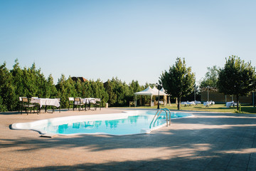 blue outdoor pool in the garden surrounded by trees
