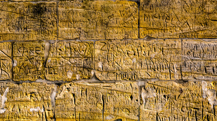 Wall with limestone bricks with illegible engravings that have been written by people with the passage of time, the Proosdij park in Meerssen south Limburg in the Netherlands Holland
