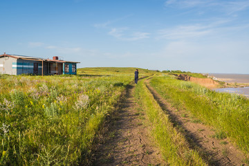 Abandoned painter's house on a green field near the sea on a blue sky background