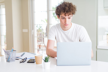 Young student man working and studying using computer laptop with a confident expression on smart face thinking serious
