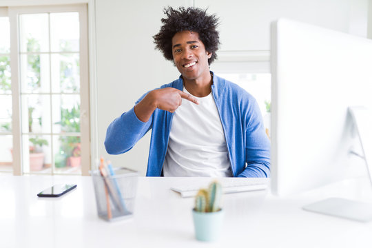 African American man working using computer with surprise face pointing finger to himself