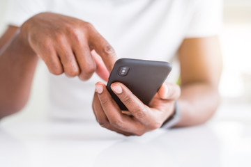 Close up of african american man hands using smartphone