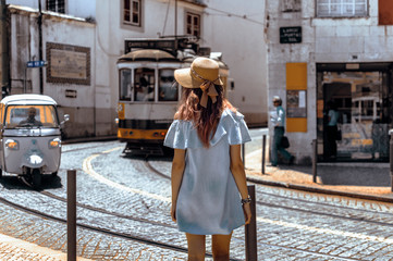 Young traveling woman walking on the streets of Lisbon city and looking at beautiful view