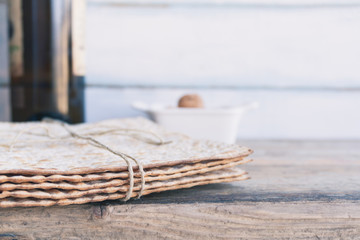 Pack of matzah or matza and red kosher wine on a vintage wood background. Jewish Passover holiday composition