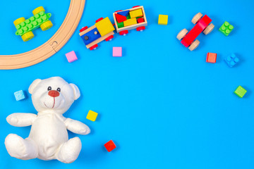 Kids toys background with teddy bear, wooden train and colorful blocks
