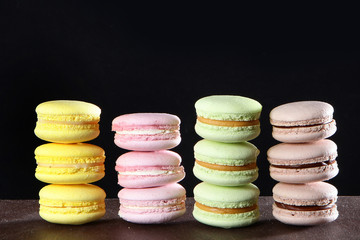 Macaroon cakes handmade on a black background. Still life concept.