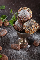 Chocolate candies with cheese and nuts in a vintage vase on a brown background. Still life concept.