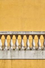 Old balustrade against yellow wall, architectural background.