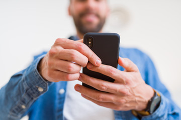 Close up of man hands using smartphone and smiling