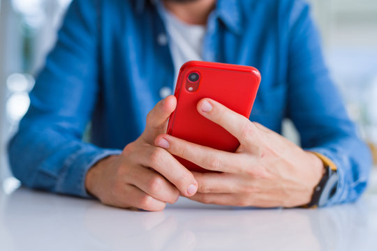 Close up of man hands using smartphone and smiling