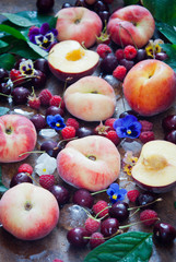 Naklejka na ściany i meble Fresh organic peaches, raspberries, cherries and flowers