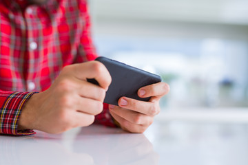 Close up of man hands using smartphone and smiling