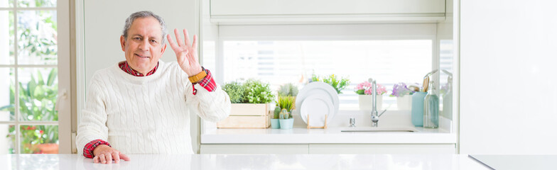 Wide angle perspective of handsome senior man at home showing and pointing up with fingers number...