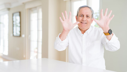 Handsome senior man at home showing and pointing up with fingers number ten while smiling confident and happy.