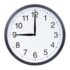 Round office clock showing nine o'clock isolated on white background