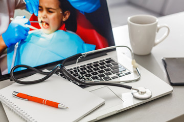 Workplace of doctor with laptop and stethoscope and notebook on white table top view shot