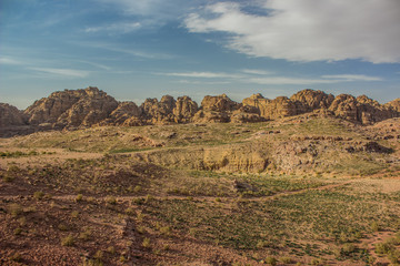 desert wilderness dry scenic landscape with big valley foreground and steep rocky highland environment of bare mountain ridge background panorama photography