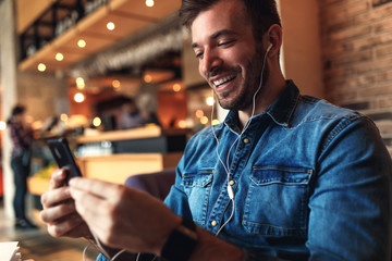 Young man sitting at cafe and making video call on smart phone.
