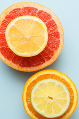 Top view of sliced fruits on blue background. Grapefruit, lime, lemon and orange.