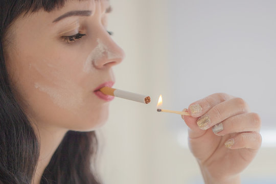 Give me fire. Close up of cigarette in hands of unhealthy girl lighting it and smoking