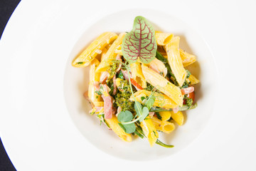 Pasta - penne with bacon and broccoli, decorated with herbs 