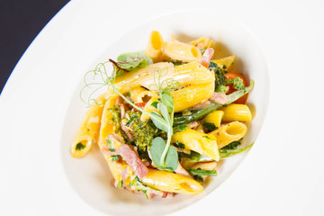 Pasta - penne with bacon and broccoli, decorated with herbs 