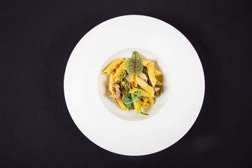 Pasta - penne with bacon and broccoli, decorated with herbs 