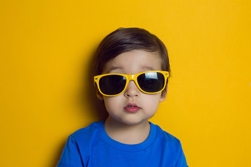 cheerful baby boy in blue t-shirt stands