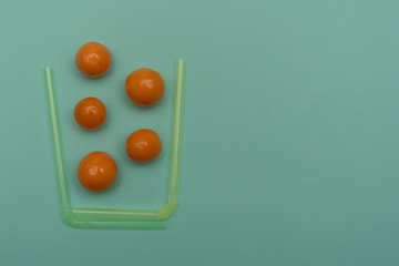 Berries falling in glass made with cocktail straws on blue background