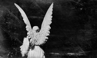 Death and  pain concept.  Retro styled antique statue of an angel against black background.