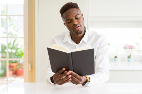 Young african man reading a book, studying for univeristy