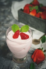 Homemade Strawberry Mousse topped with berries and mint leaf garnish, selective focus