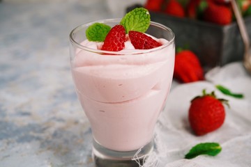 Homemade Strawberry Mousse topped with berries and mint leaf garnish, selective focus