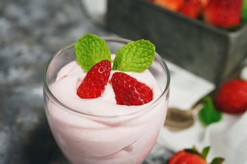 Homemade Strawberry Mousse topped with berries and mint leaf garnish, selective focus