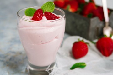 Homemade Strawberry Mousse topped with berries and mint leaf garnish, selective focus