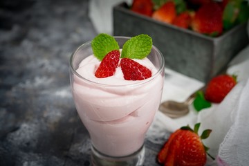 Homemade Strawberry Mousse topped with berries and mint leaf garnish, selective focus
