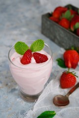 Homemade Strawberry Mousse topped with berries and mint leaf garnish, selective focus