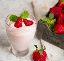 Homemade Strawberry Mousse topped with berries and mint leaf garnish, selective focus