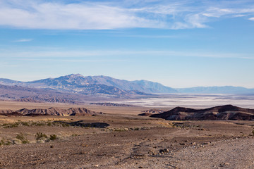 Looking down into Death Valley, California, with salt flats and rugged mountains beneath a blue sky