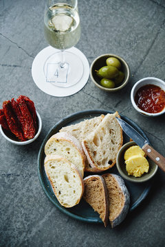 Bread, butter, dryed tomatoes, olives anf jam