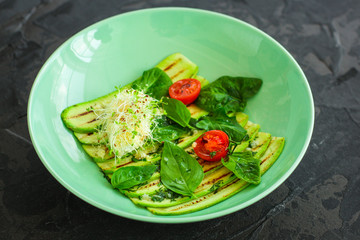 zucchini grilled with tomatoes and cream cheese, sauce and micro-greens (warm salad appetizer). food background. copy space