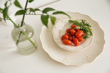 tomatoes and greens on the white table