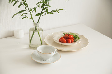 tomatoes and greens on the white table